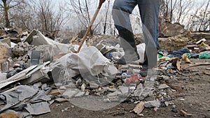 Close-up male legs walking at garbage dump site