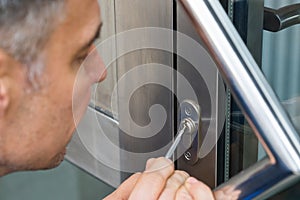 Close-up Of Male Lockpicker Fixing Door Handle At Home