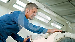 Close-up male mechanic hand, who is sloppy wiping parts car, removed clean, Before being sprayed with new paint,