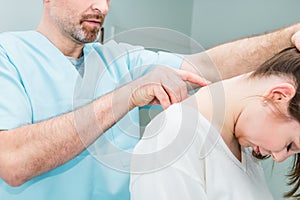 Close up Male neurologist doctor examines cervical vertebrae of female patient spinal column in medical clinic. Neurological physi