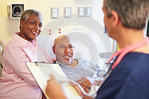 Close Up Of Male Nurse Updating Patient Notes