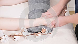 Close-up of a male physiotherapist doing foot massage to a young girl in a beauty and health spa. Foot and body care