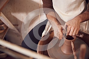 Close Up Of Male Potter Shaping Clay For Pot On Pottery Wheel In Ceramics Studio