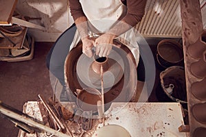 Close Up Of Male Potter Shaping Clay For Pot On Pottery Wheel In Ceramics Studio