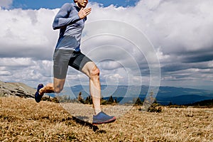 close up male runner running on mountain trai