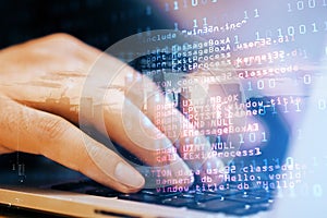 Close up of male student hand using laptop keyboard with abstract html code on creative city background. Coding and programming
