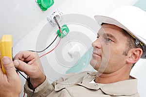 close-up male technician doing meter reading using mobilephone