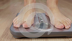 Close up male or woman foot stepping on weight scale for weighting body