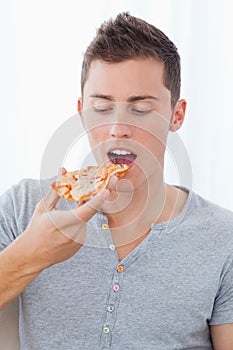 Close up of a man as he is about to eat the slice of pizza he is