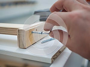 close-up of a man assembling furniture, close-up