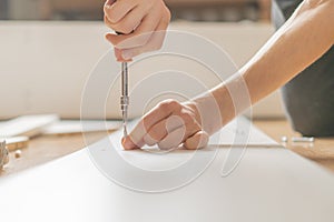 Close up man assembling new furniture with a screwdriver b