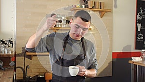 Close-up of a man barista poured into a strong aromatic coffee cinnamon or cocoa