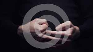 Close-up man beats his fist in the palm, isolate on black background