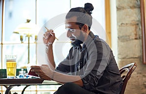 Close up of man with beer and notebook at pub