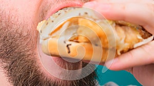 Close up of a man biting a burger on a Chroma Key. The concept of unhealthy and unhealthy diets, high cholesterol.