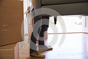 Close Up Of Man Carrying Sofa Into New Home On Moving Day