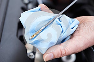 Close-Up Of Man Checking Car Engine Oil Level On Dipstick