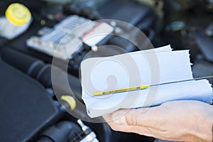 Close-Up Of Man Checking Car Engine Oil Level On Dipstick