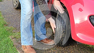 Close up of man checking tire or tyre tread.