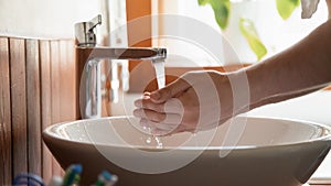 Close up of man clean hands under tap water