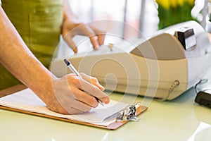 Close up of man with clipboard at flower shop