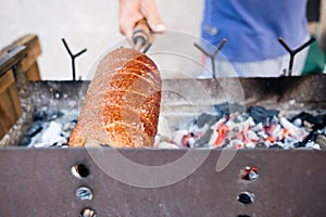 Close up of man cooking and baking  sweet romanian horn bread known as KÃ¼rtÃ¶s kalÃ¡cs in outdoor street food market