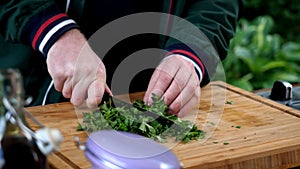 Close up man is cooking parsley wooden table.