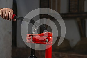 close-up of a man corking a bottle of wine at a winery .