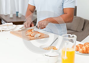 Close up of a man cutting bread during breakfast