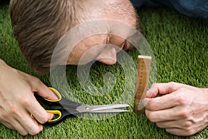 Man Using Measuring Scale While Cutting Grass