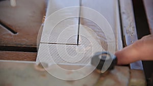 Close-up of a man cutting tiles and granite with an electric circular saw and applying water to it