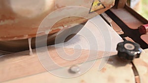 Close-up of a man cutting tiles and granite with an electric circular saw and applying water to it