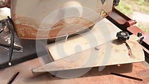 Close-up of a man cutting tiles and granite with an electric circular saw and applying water to it