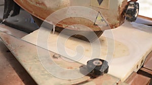 Close-up of a man cutting tiles and granite with an electric circular saw and applying water to it