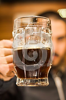 Close up of a man dolding a dark beer, delicious craft beer Booze Brew Alcohol Celebrate