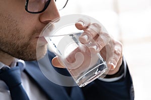Close up of man drink pure mineral water from glass