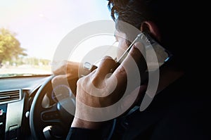 Close up of a man driving car dangerously using telephone