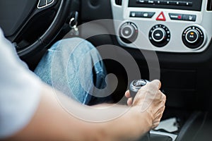 Close up of man driving car and using gear shift