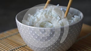 Close-up of a man eating with chopsticks rice from a bowl
