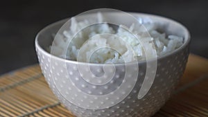 Close-up of a man eating with chopsticks rice from a bowl