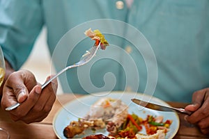 Close up of man eating with fork and knife