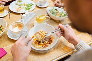 Close up man eating pasta for dinner at restaurant