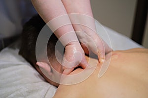 Close-up of man enjoying in relaxing neck massage . Man relaxing on massage table receiving massage