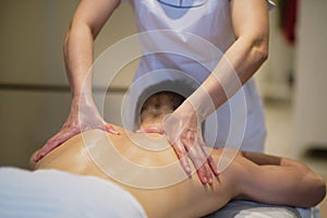 Close-up of man enjoying in relaxing shoulders massage . Man relaxing on massage table receiving massage