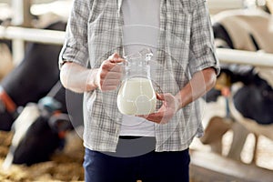 Close up of man or farmer with milk on dairy farm