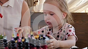 Close-up of a man feeding a little daughter in a cafe in the morning.