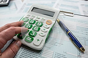 Close up man filling 1040 individual income tax form. Tax time