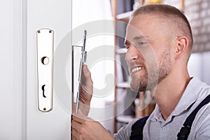 Close-up Of A Man Fixing Door Lock