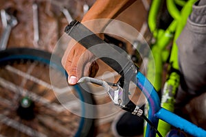 Close up of man fixing the handlebar of the bicycle, in a workshop photo