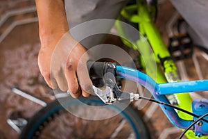 Close up of man fixing the handlebar of the bicycle, in a workshop photo